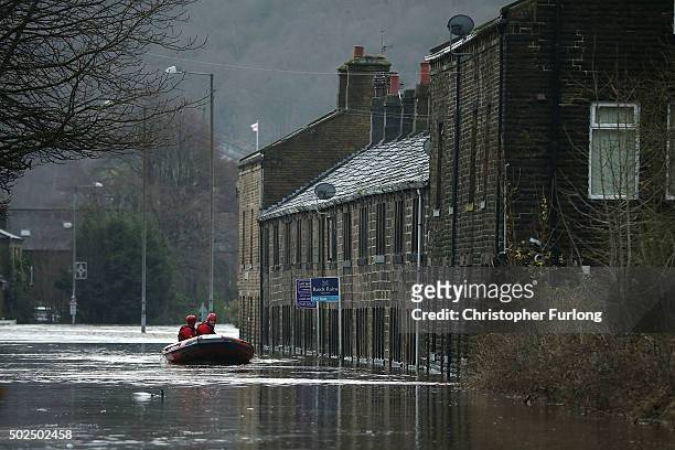 Rescue workers patrol the waters after the River Calder bursts its bank's on December 26, 2015 in Mytholmroyd, England. There are more than 200 flood...