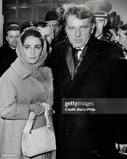 Way through the crowd of movie fans; reporters; Elizabeth Taylor and Richard Burton Edward hotel after their drive from Toronto International...