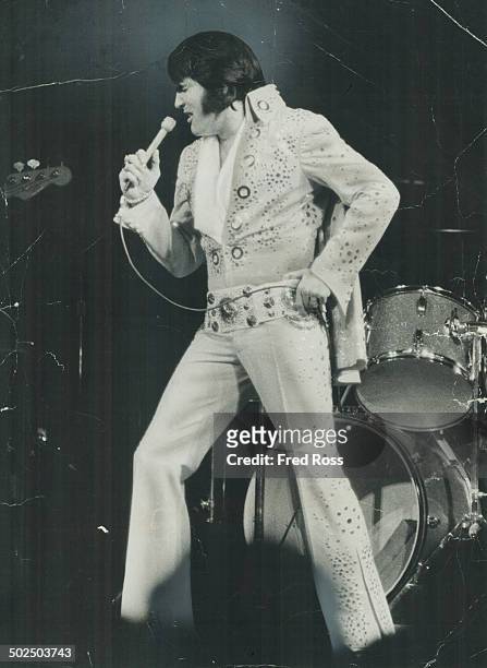 Lue jump-suit and cape; Elvis Presley looked a high-fashion version of Superman in concert at Buffalo's Memorial Auditorium last night. Fans flew in...