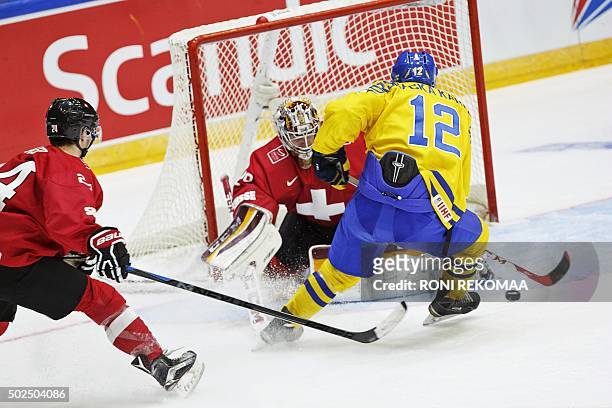 Sweden's Jakob Forsbacka Karlsson scores the 2-6 goal past Switzerland's goalkeeper Gauthier Descloux and Pius Suter during the 2016 IIHF World...