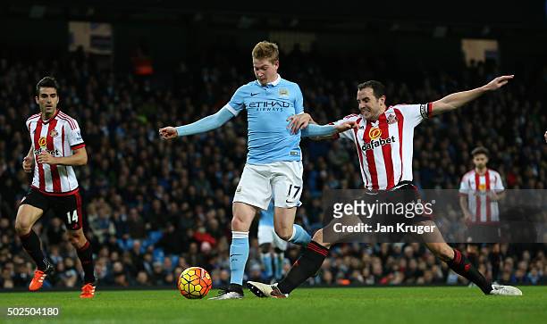 Kevin De Bruyne of Manchester City holds off the challenge from John O'Shea of Sunderland to score his team's fourth goal during the Barclays Premier...