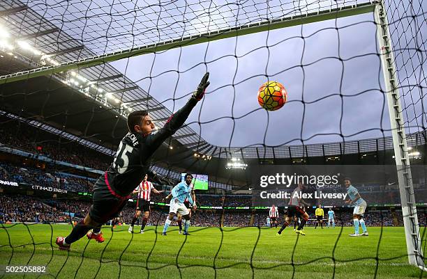 Vito Mannone of Sunderland dives in vain as Raheem Sterling of Manchester City scores the opening goal during the Barclays Premier League match...