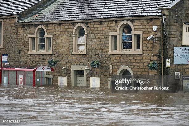 Residents look out fom their homes trapped by flood water as the River Calder bursts its bank's in the Calder Valley town of Mytholmroyd on December...