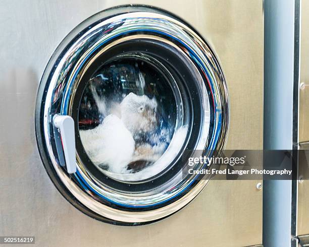 clothes in commercial washer at laundromat - washing machine with bubbles stock pictures, royalty-free photos & images