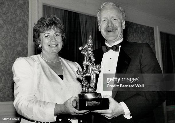 Cartoonist feted: Kathleen Andrews and Lee Salem of Universal Press Syndicate accept Bill Watterson's award last night for best cartoonist of 1988.