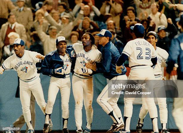 Escort for Shaker: A squadron of Blue Jays raced from the dugout to greet a hatless Lloyd Moseby after he had roared home from second with the...