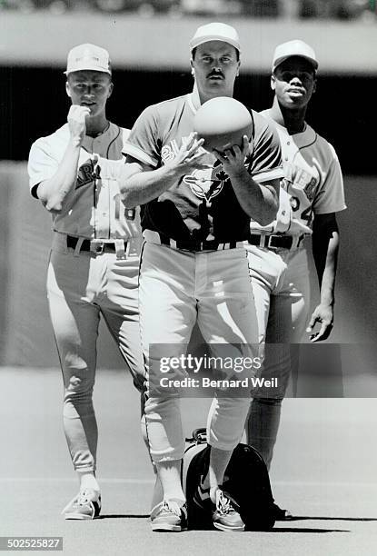 Throwing strikes: That's Blue Jays pitcher David Wells splitting Mariners' Bill Swift; left; and Ken Griffey Jr. As the teams took part in a pre-game...