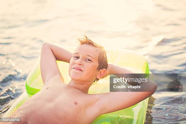 Happy Smiling Boy On An Inflatable Float Dreaming High-Res Stock Photo ...