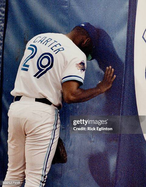 Slam dance: Blue Jays' outfielder Joe Carter leans his head against the wall last night after Atlanta's Lonnie Smith smacked a grand slam homer to...