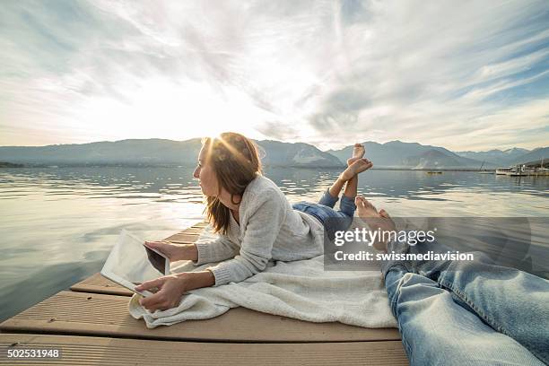 junges paar liegen auf steg über dem see, die mit digitalen tablet - ungewöhnliche perspektive stock-fotos und bilder