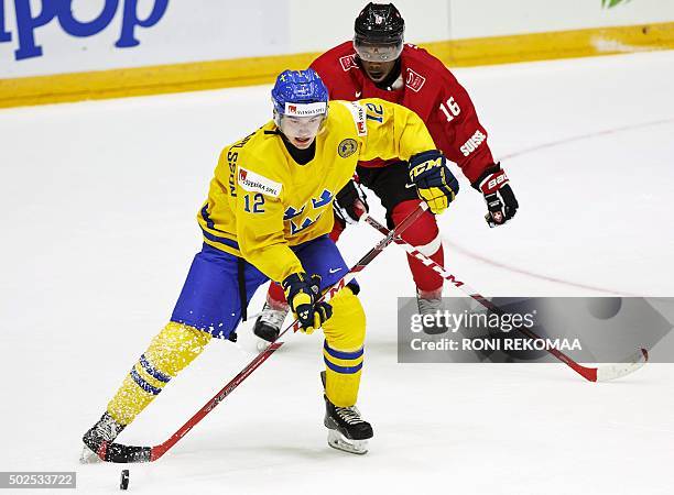 Switzerland's Auguste Impose chases Sweden's Jakob Forsbacka Karlsson during the 2016 IIHF World Junior Ice Hockey Championship match between...