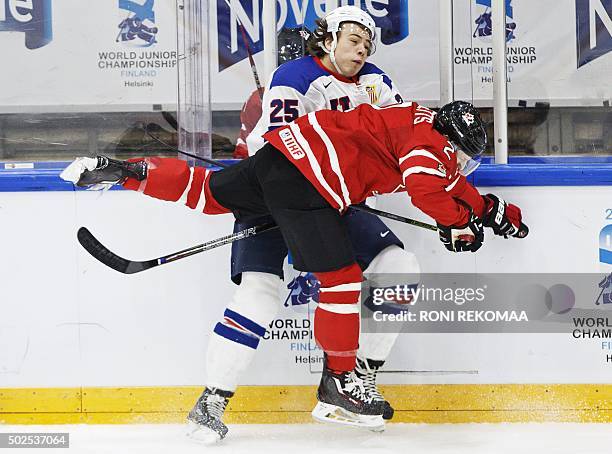 Canada's Joe Hicketts tackles USA's Charlie McAvoy Jr during the 2016 IIHF World Junior Ice Hockey Championship match between USA and Canada in...