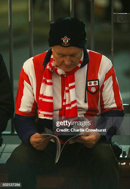 Fan reads a matchday programme walk outside the stadium prior to the Barclays Premier League match between Southampton and Arsenal at St Mary's...