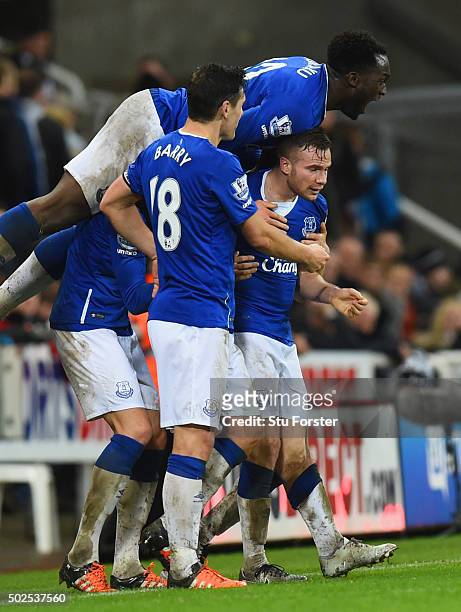 Tom Cleverley of Everton is mobbed by team mates in celebration as he scores their first goal during the Barclays Premier League match between...