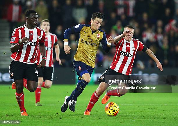 Mesut Ozil of Arsenal goes between Victor Wanyama and Jordy Clasie of Southampton during the Barclays Premier League match between Southampton and...