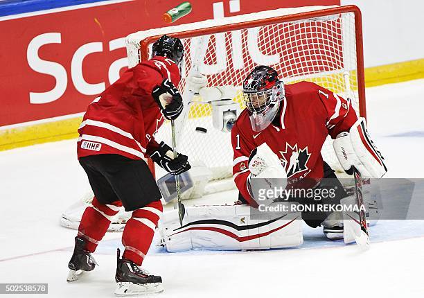 Canada's goalkeeper Mason McDonald and Joe Hicketts fail to stop the puck during the 2016 IIHF World Junior Ice Hockey Championship match between USA...