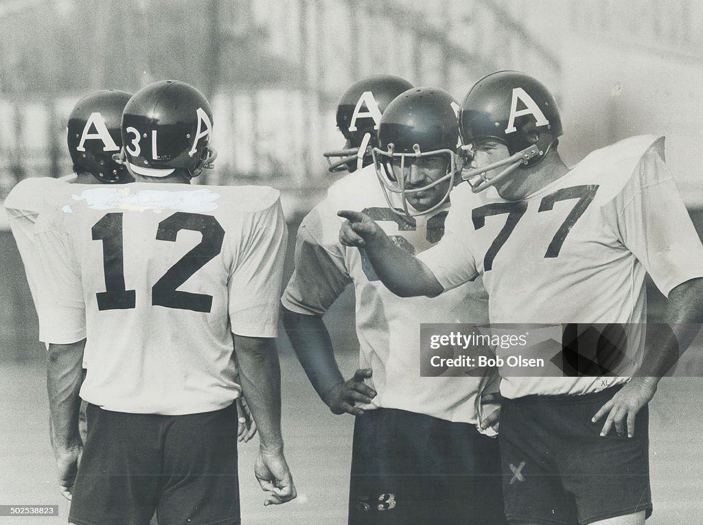 Talking things over: Veteran Canadian linebacker Pete Martin (77) discusses strategy with Jim Stillw