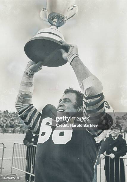 His last game: Angelo Mosca shows off the Grey Cup to the delight of the roaring Hamilton fans yesterday at Ivor Wynne Stadium. For Big Angie; it was...