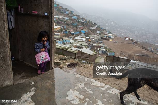 Child looks out from the slum in Surco neighborhood of Lima on December 26, 2015. Peru's ten-foot high 'Wall of Shame' topped with razor wire...