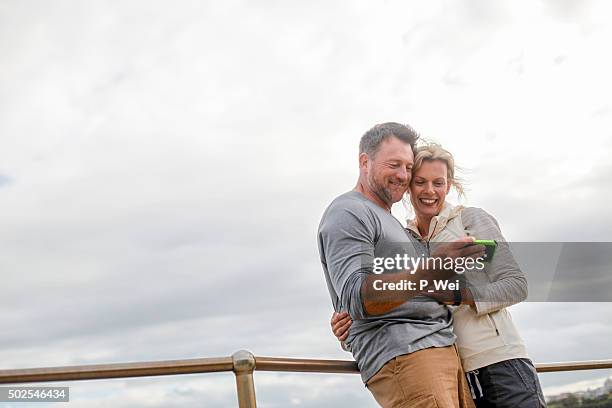 man and woman looking at smartphone - 2015 45 50 stock pictures, royalty-free photos & images