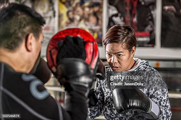 boxing: practice training with punch pads in a boxing ring - padding stock pictures, royalty-free photos & images