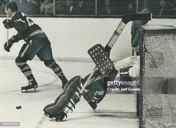 That kind of night: Detroit Red Wing goalie Roger Crozier grabs at the cossbar as he tumbles backward into nets after missing shot by Leafs' Pat...