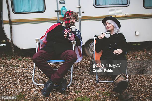 camper holding stahl becher aufwärmen in der nähe von fire - motorhome winter stock-fotos und bilder