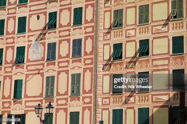 Colorfully painted facades of houses along the waterfront of the small fishing port of Camogli on the Italian Riviera in Liguria Italy.