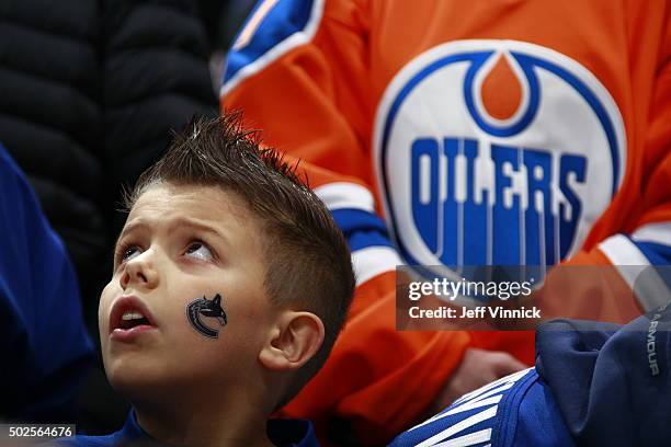 Young fan checks the scoreboard before the NHL game between the Vancouver Canucks and the Edmonton Oilers at Rogers Arena December 26, 2015 in...