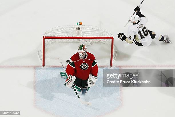 Eric Fehr of the Pittsburgh Penguins celebrates after scoring a goal as Devan Dubnyk of the Minnesota Wild reacts during the game on December 26,...