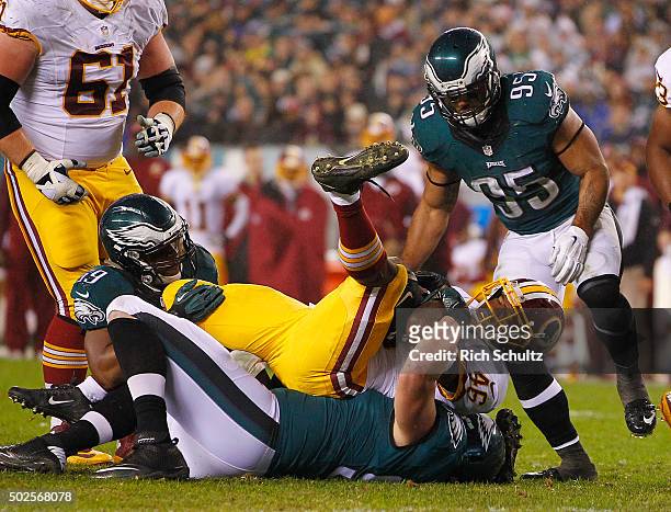 Alfred Morris of the Washington Redskins is tackled by DeMeco Ryans and Taylor Hart of the Philadelphia Eagles in the fourth quarter of a football...