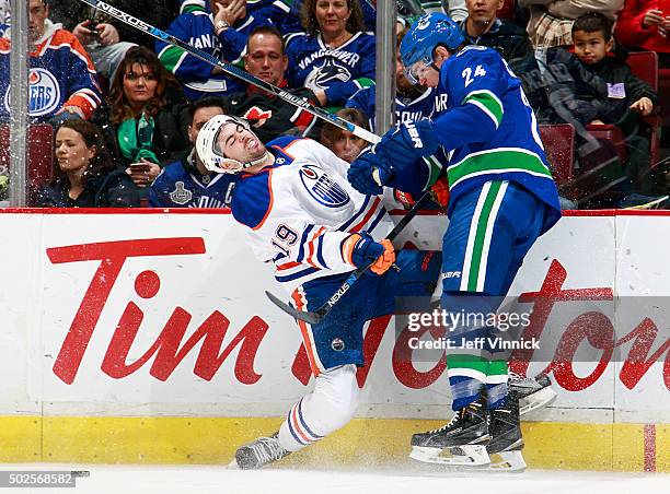 Adam Cracknell of the Vancouver Canucks collides with Justin Schultz of the Edmonton Oilers during their NHL game at Rogers Arena December 26, 2015...