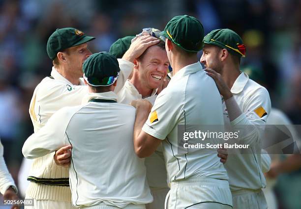 Peter Siddle of Australia is congratulated by his teammates after dismissing Jason Holder of the West Indies during day two of the Second Test match...