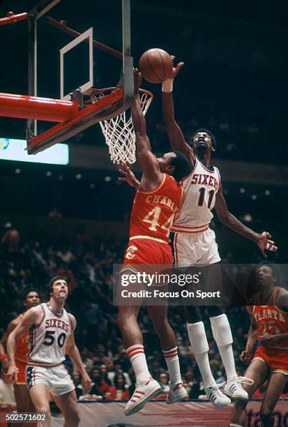 Caldwell Jones of the Philadelphia 76ers blocks the shot of Ken Charles of the Atlanta Hawks during an NBA basketball game circa 1977 at The Spectrum...