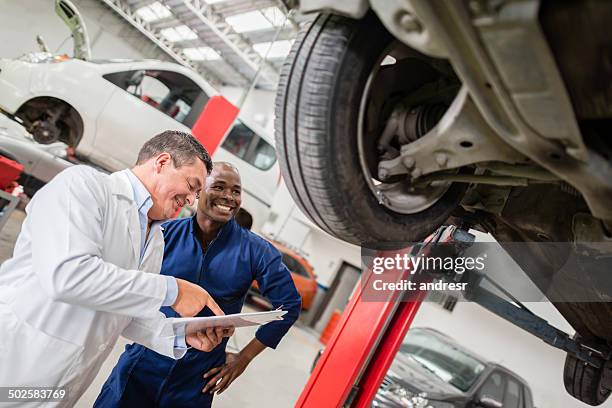 mechanics at a car garage - broken friendship stock pictures, royalty-free photos & images