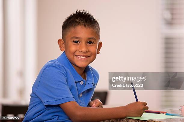 cute hispanic boy does homework in home kitchen. - 8 9 years stock pictures, royalty-free photos & images