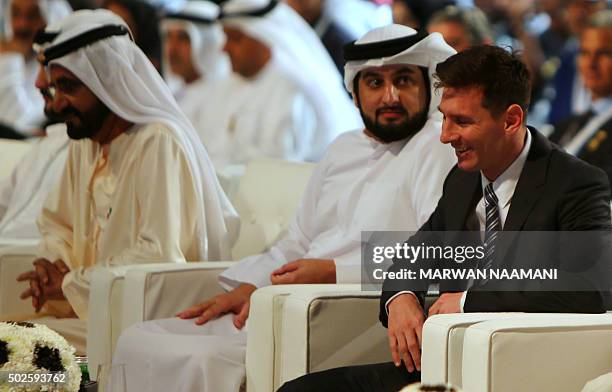 Barcelona football striker Lionel Messi smiles as he sits next to Sheikh Ahmed Bin Mohamed Bin Rashid al-Maktoum and his father Shiekh Mohamed Bin...