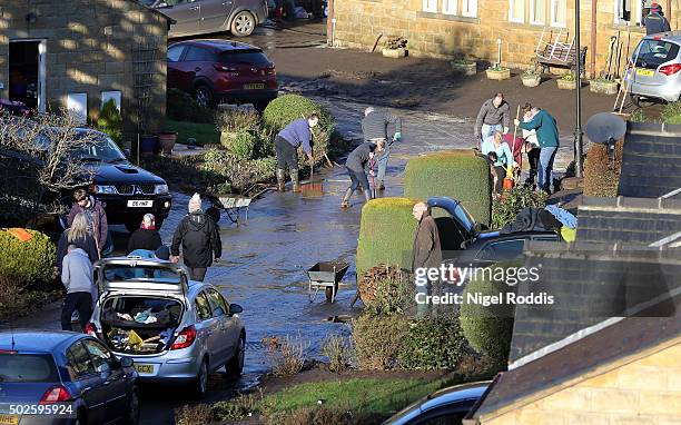 Residents clean up their street after flooding on December 27, 2015 in Mytholmroyd, England. Heavy rain has caused more flooding in northern England,...