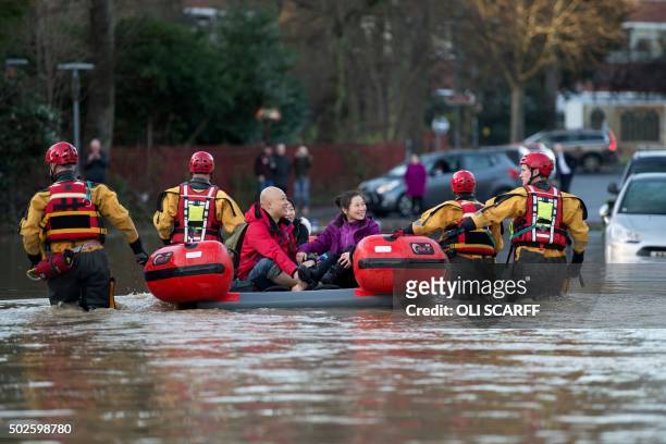 Members of the emergency services transport residents to safety after their homes were affected by floodwaters by the adjacent River Foss bursting...