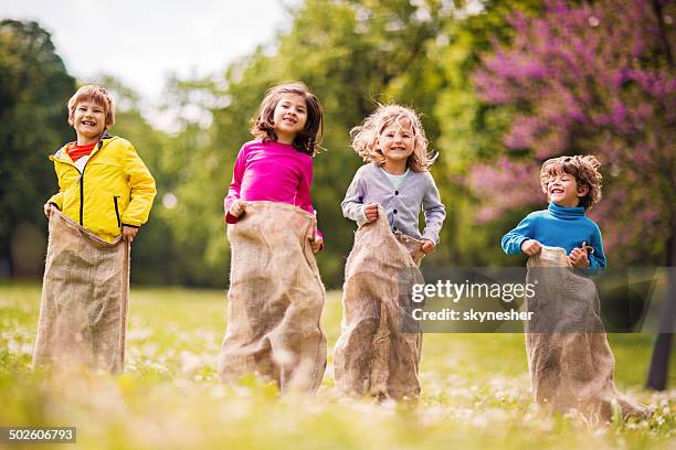 children having sack race. - sack race stock pictures, royalty-free photos & images