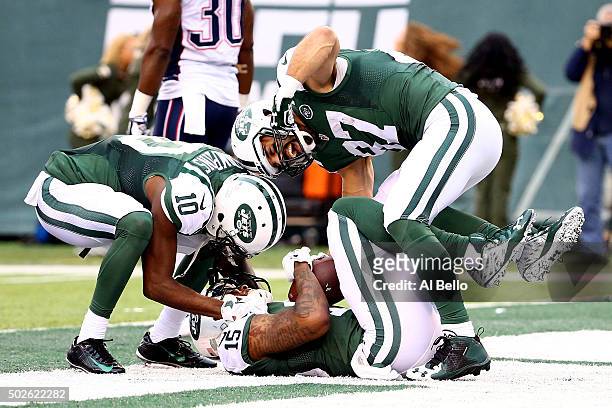 Brandon Marshall of the New York Jets celebrates with his teammates Kenbrell Thompkins and Eric Decker after scoring a 33 yard touchdown in the third...