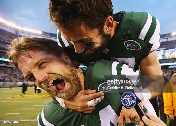 Eric Decker of the New York Jets jumps on the back of Ryan Fitzpatrick of the New York Jets during a television interview after their 26-20 overtime...