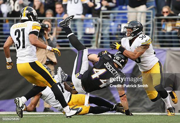 Kyle Juszczyk of the Baltimore Ravens makes a catch with pressure from Jordan Todman of the Pittsburgh Steelers at M&T Bank Stadium on December 27,...