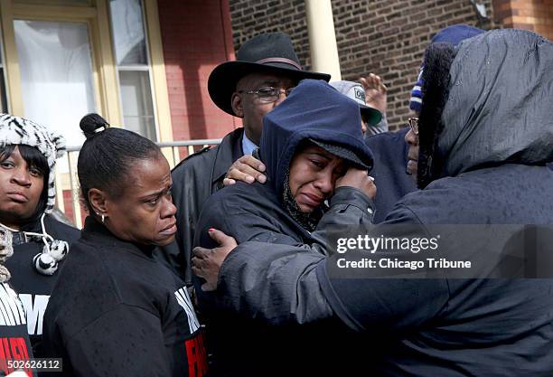 Janet Cooksey, center, the mother of Quintonio LeGrier, is comforted by family and friends during a press conference on Sunday, Dec. 27 to speak out...