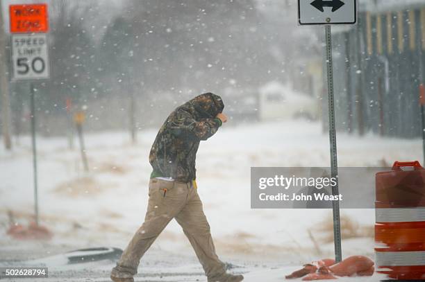 Highway worker tries to shield himself while walking to his truck on December 27, 2015 in Lubbock, Texas. Coming on the heels of several strong...