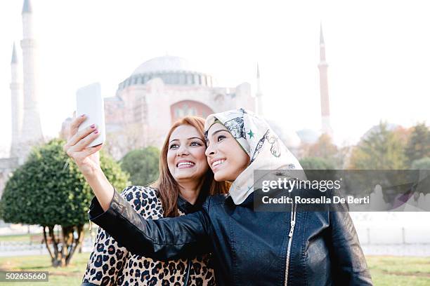 portrait of two cheerful women taking selfies in istanbul - istanbul stockfoto's en -beelden