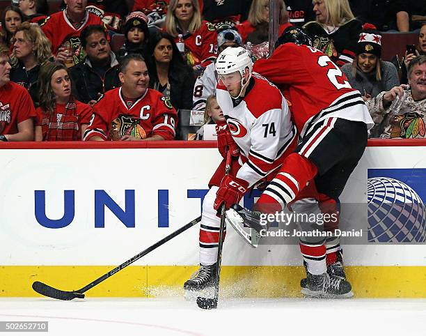 Jaccob Slavin of the Carolina Hurricanes battles for the puck along the boards with Ryan Garbutt of the Chicago Blackhawks at the United Center on...