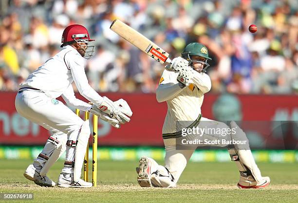 Usman Khawaja of Australia bats as wicketkeeper Denesh Ramdin of the West Indies looks on during day three of the Second Test match between Australia...