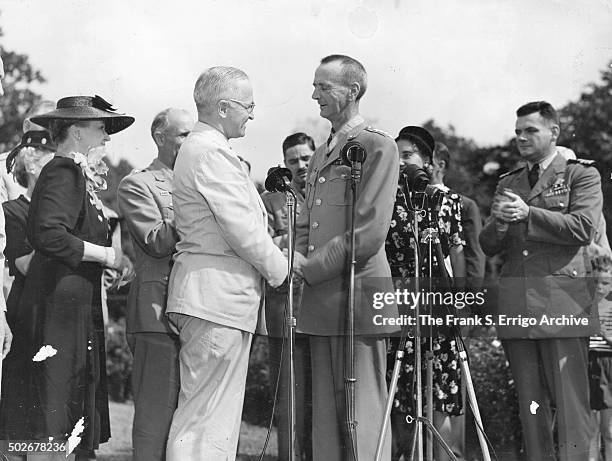 On the White House grounds, American politician and US President Harry S Truman shakes hands with General Jonathan M Wainwright during a ceremony to...