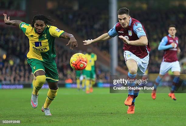 Dieumerci Mbokani of Norwich City and Ciaran Clark of Aston Villa compete for the ball during the Barclays Premier League match between Norwich City...